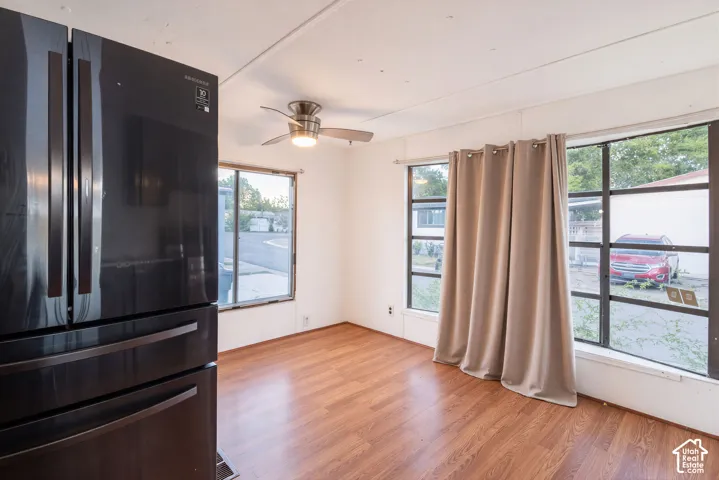 Wood-finish flooring throughout, multiple pane windows, and a ceiling fan with integrated lighting