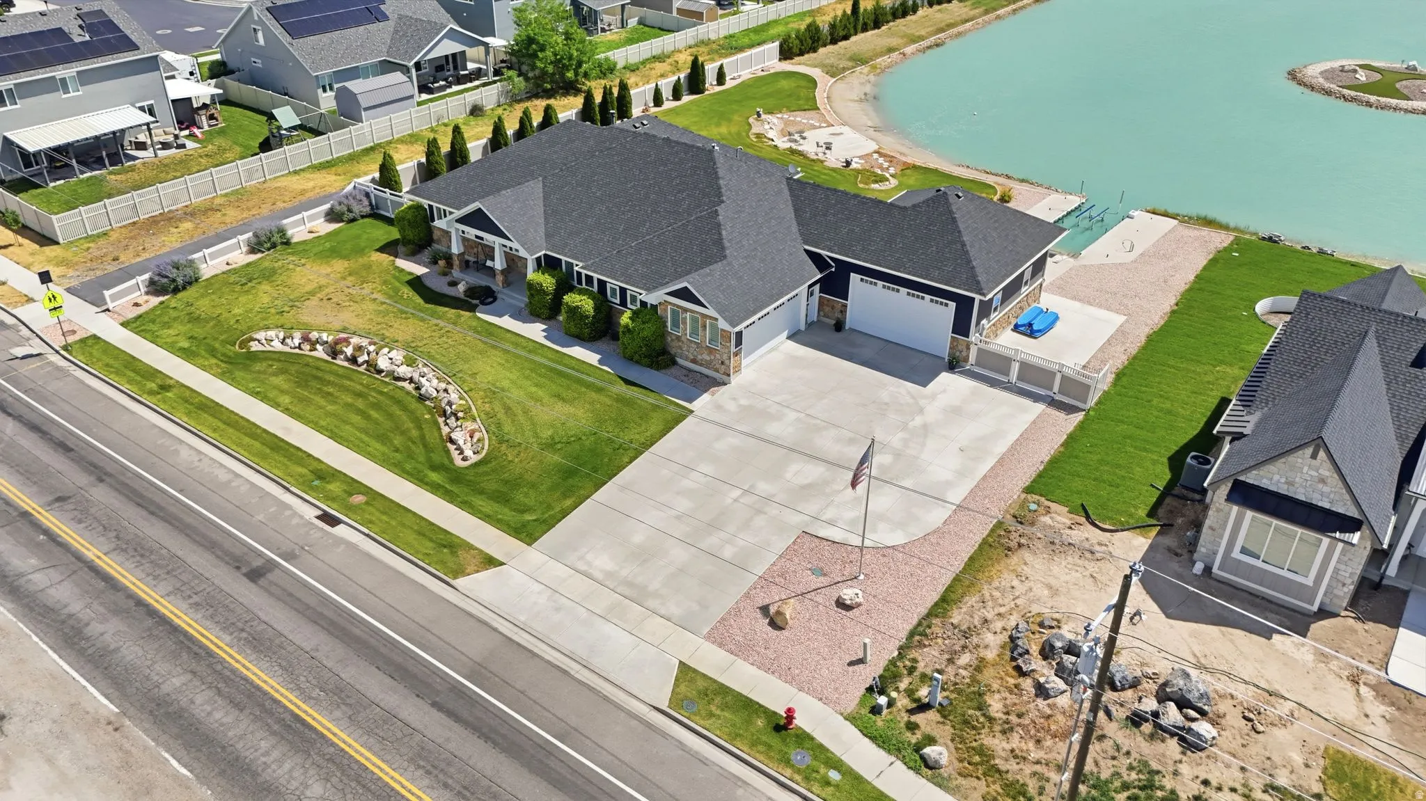 Contemporary residence featuring a dark shingle roof, light stone accents, and dark siding