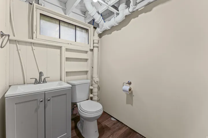 Powder room featuring a modern vanity with integrated sink, chrome faucet, and a toilet