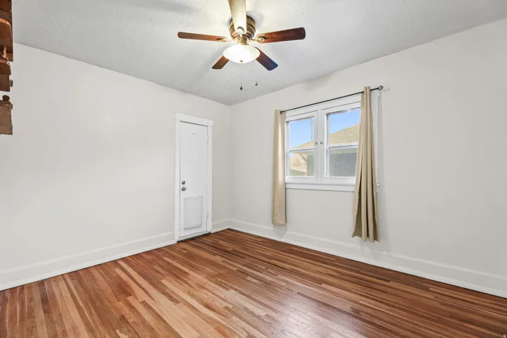 Room with wood flooring, white walls, and a multi-pane window