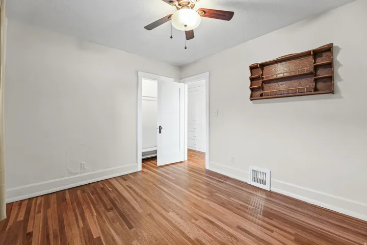 Hardwood flooring throughout featuring white trim and walls