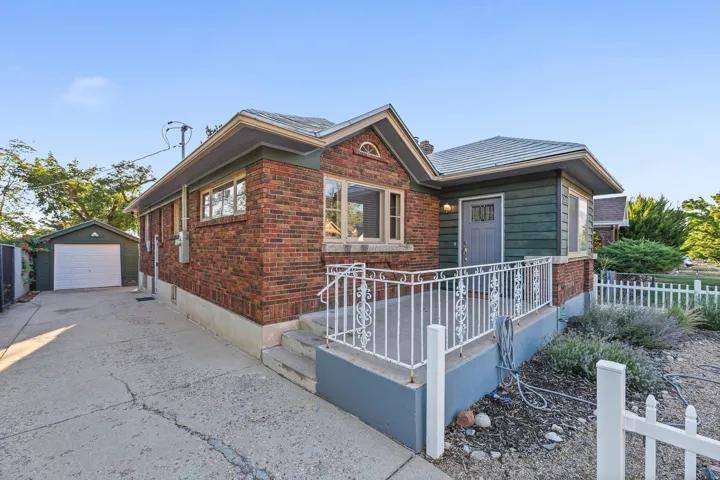 Brick and siding exterior featuring a covered front porch with decorative white railings