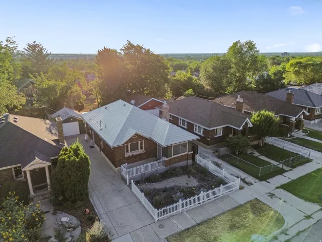 Aerial perspective showcasing a brick residence with a light-colored, gabled roof