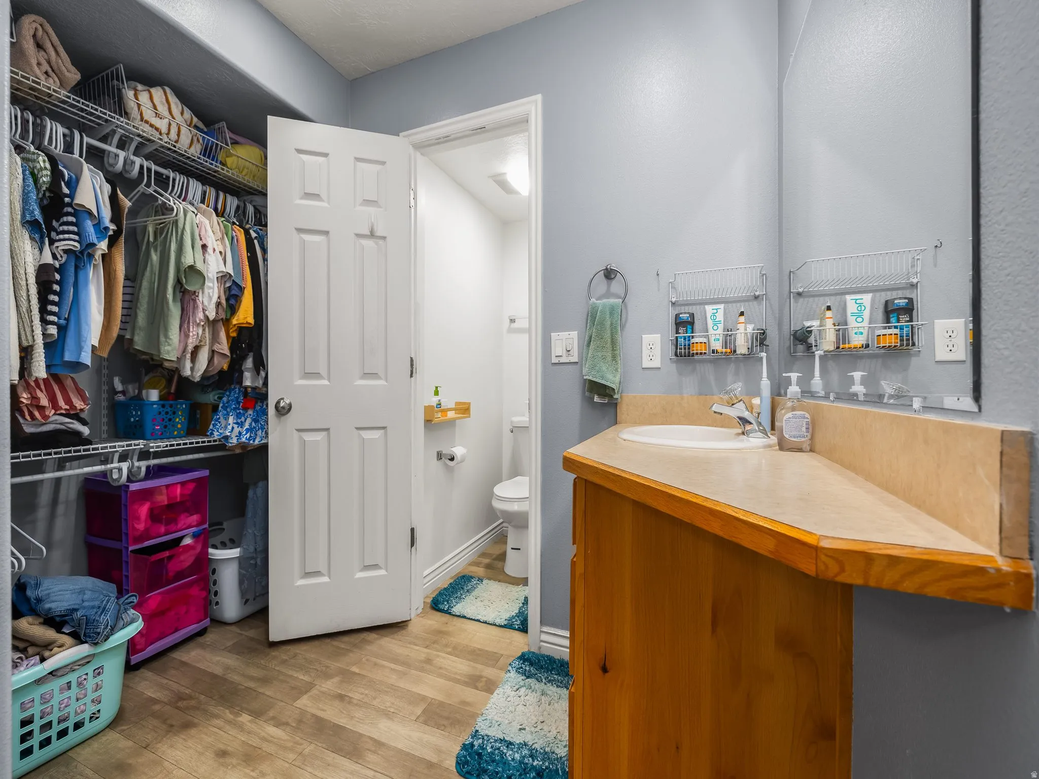 Bathroom featuring a wood-finish vanity with an integrated sink and a large wall-mounted mirror