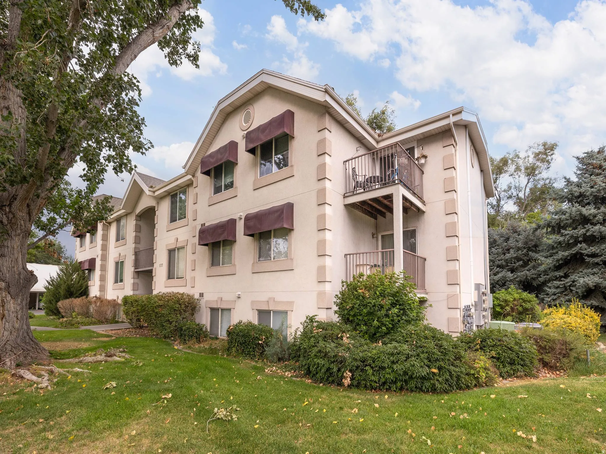 Multi-story residential building featuring a stucco exterior with decorative trim