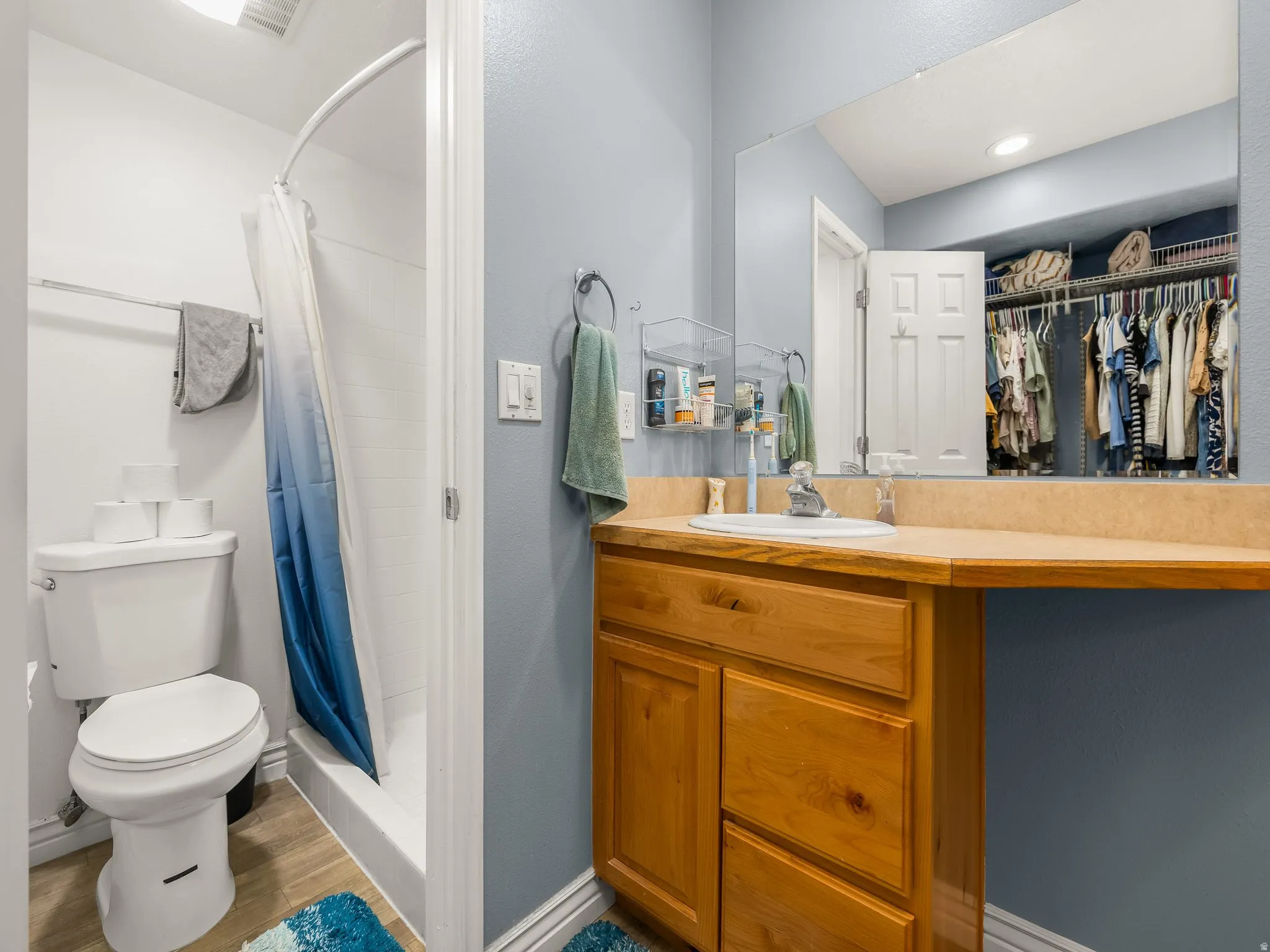 Full bathroom featuring a single vanity with wood cabinetry, an integrated sink, and a light-colored countertop
