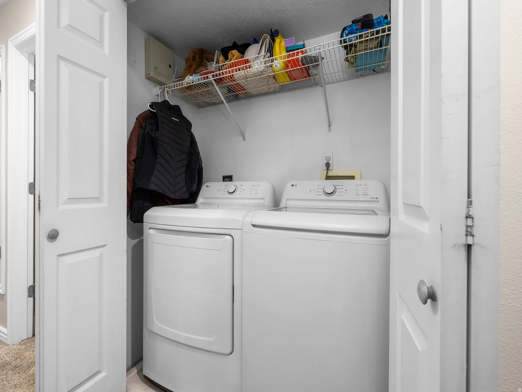 Dedicated laundry area featuring a white top-load washing machine and a white front-load dryer