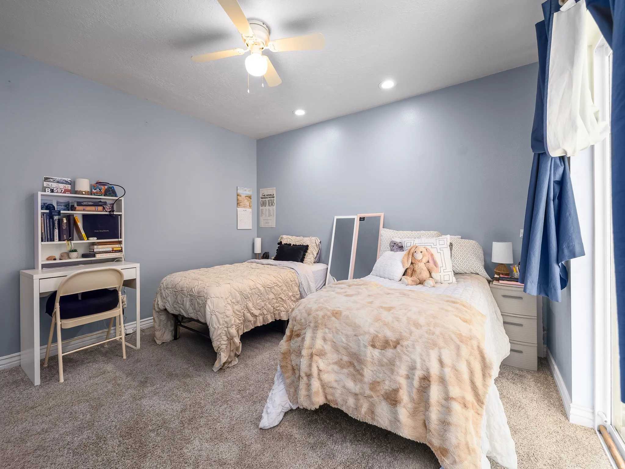 Bedroom featuring light blue walls and plush grey carpeting