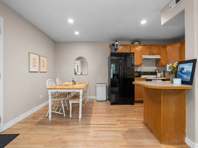 Open-concept kitchen and dining area featuring wood-finish flooring