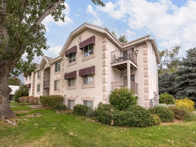 Multi-story residential building featuring a stucco exterior with decorative trim