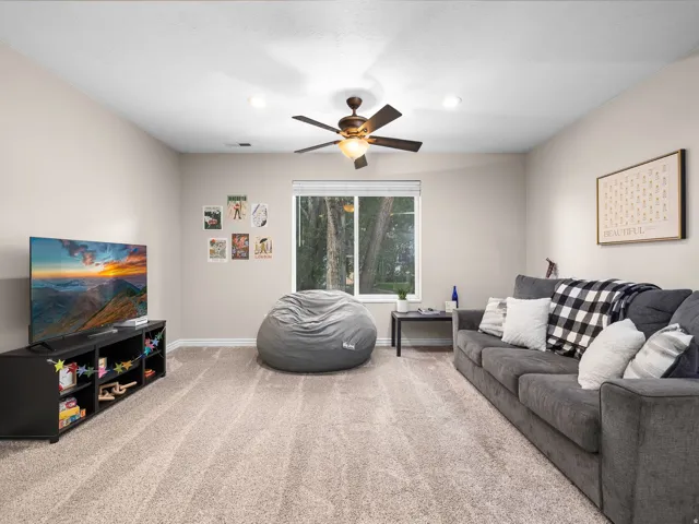 Spacious room featuring neutral wall tones, recessed lighting, and a ceiling fan