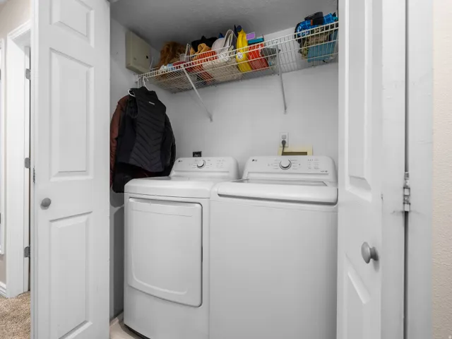 Dedicated laundry area featuring a white top-load washing machine and a white front-load dryer