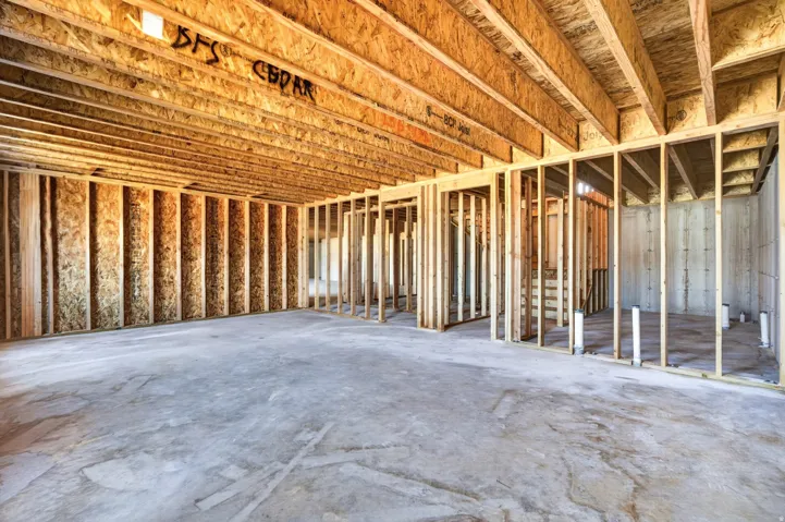 Unfinished basement with concrete flooring and exposed wood framing