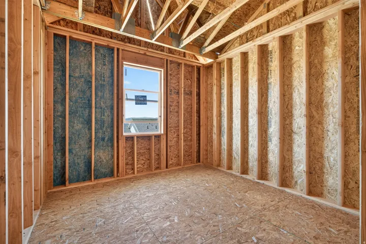Framed interior room featuring exposed wood studs, oriented strand board (OSB) subflooring, and a framed window opening