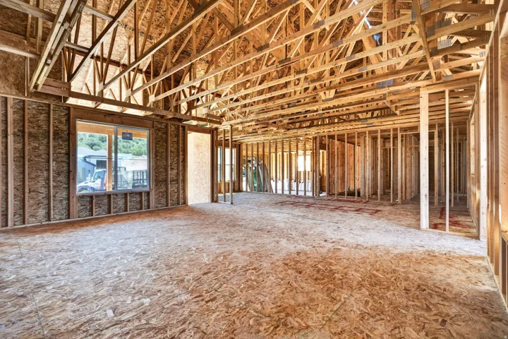 New construction framing showcasing extensive lumberwork and a spacious floor plan