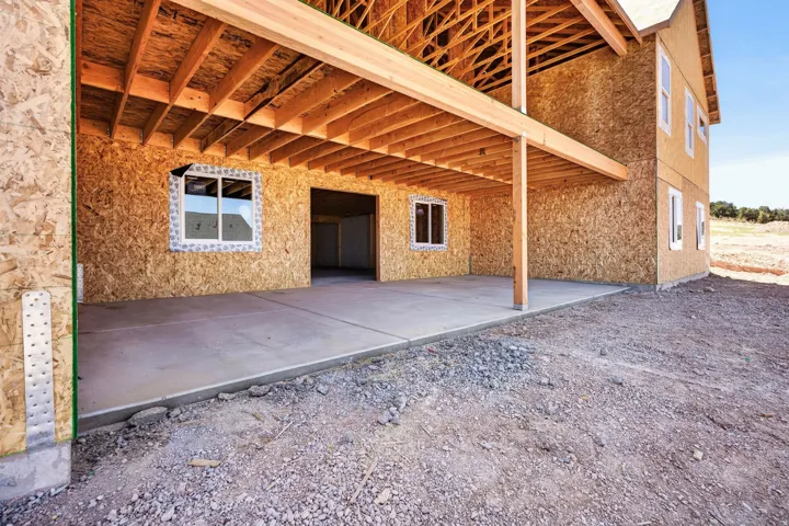 Unfinished lower level with concrete slab, exposed wood framing, and multiple window openings