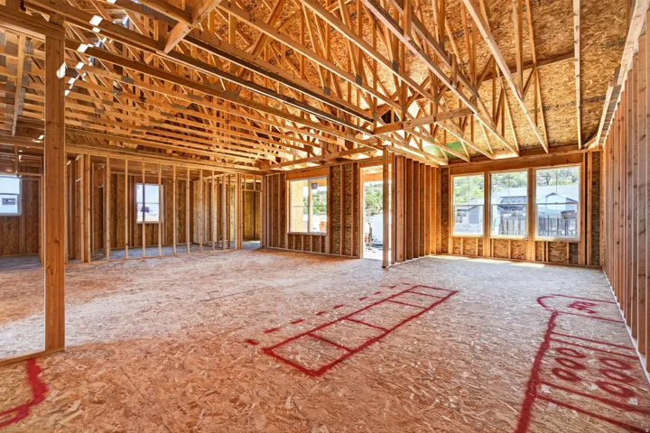 New construction framing with exposed wooden studs and ceiling joists