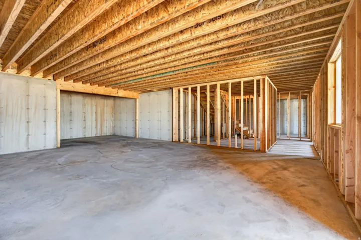 Unfinished basement featuring extensive wood framing, concrete flooring, and exposed ceiling joists