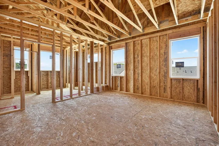Unfinished interior space with exposed wood framing, oriented strand board walls, and subflooring