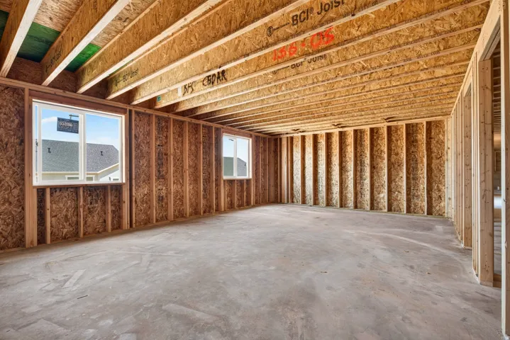 Unfinished interior space featuring exposed wood framing, wood joists, and a concrete slab floor