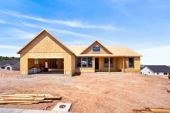 New construction residence featuring a front-facing garage, covered entry, multiple window designs, and a visible roofline