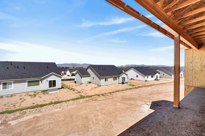 New construction framing offering an expansive outlook, with multiple modern-style homes featuring dark shingle roofs and light-colored siding