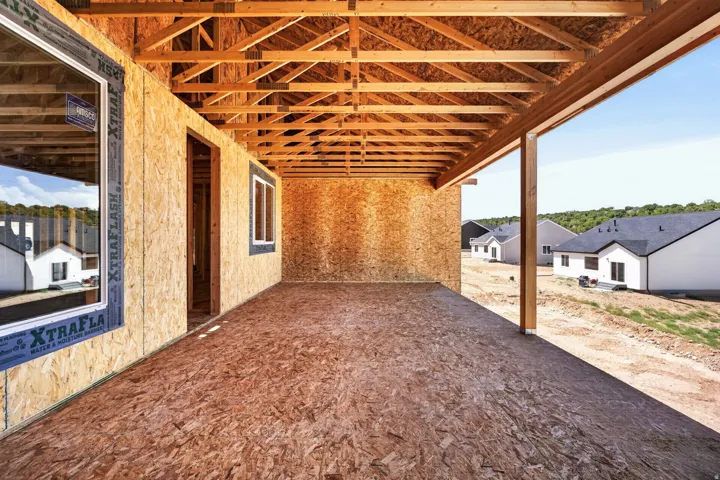 Covered porch under construction featuring exposed wood framing and a manufactured wood subfloor