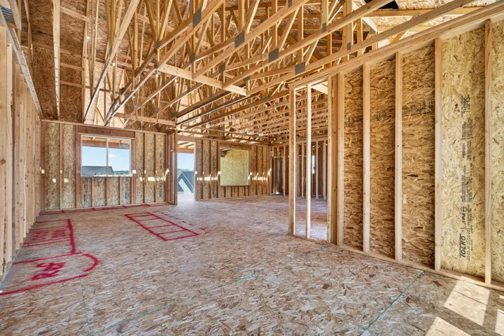 Spacious unfinished interior featuring exposed wood framing and engineered wood subflooring