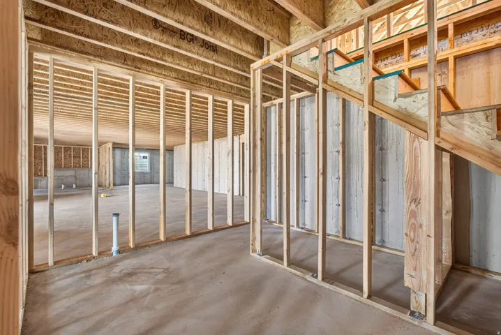 Unfinished lower level featuring wood framing and exposed concrete walls