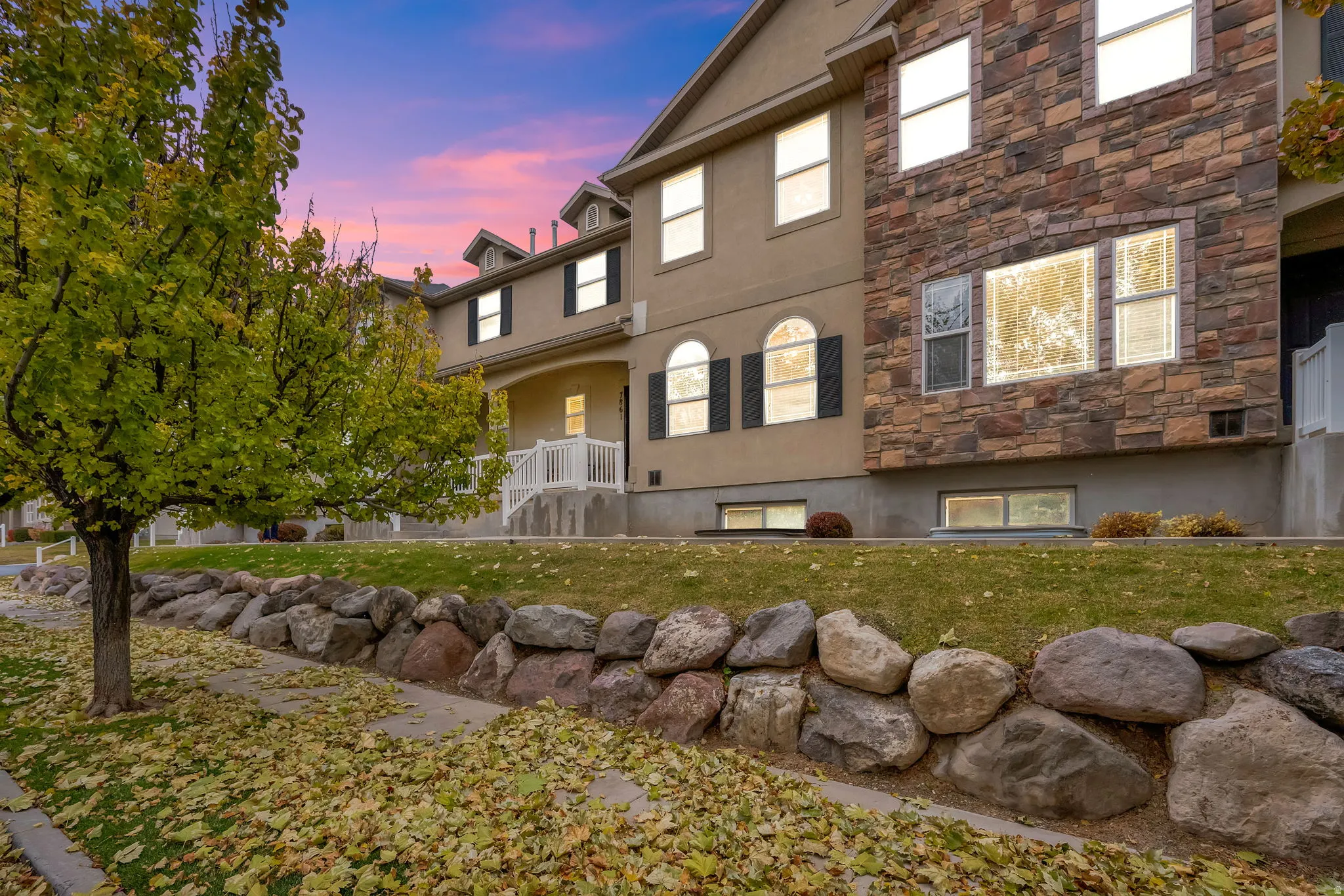 Multi-story exterior featuring stone and stucco finishes