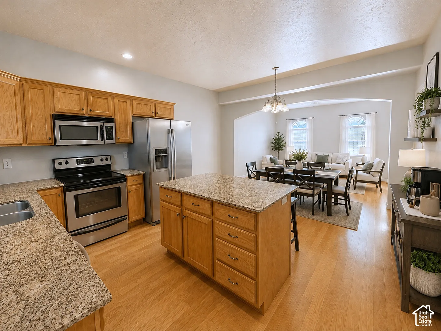 Kitchen with wood-finish flooring, light-toned cabinetry, and granite-style countertops