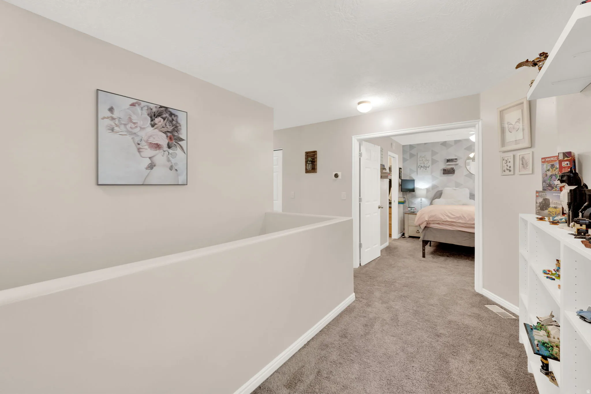 Open hallway with neutral wall tones and plush carpet flooring