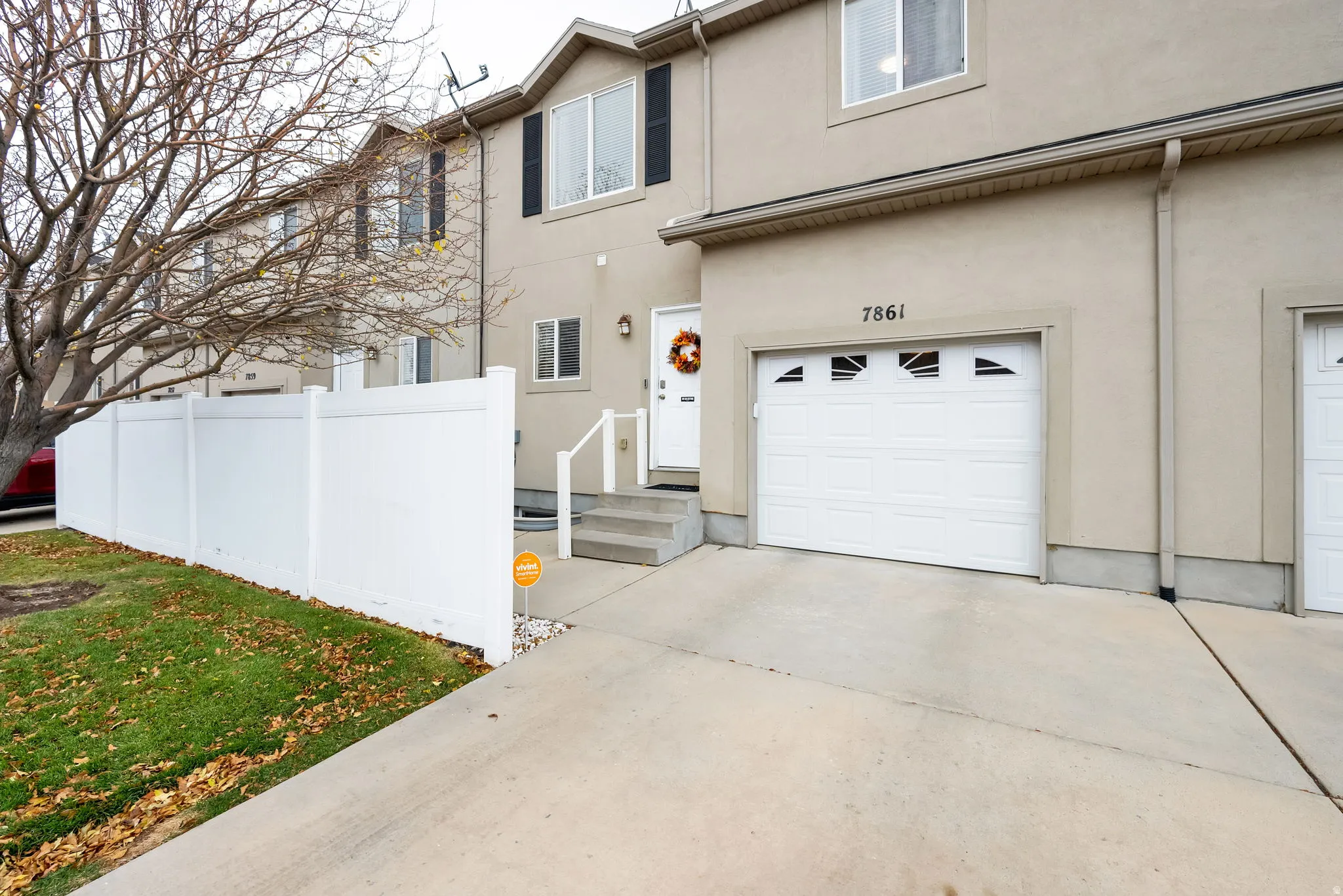 Stucco exterior with a single-car garage featuring a windowed door