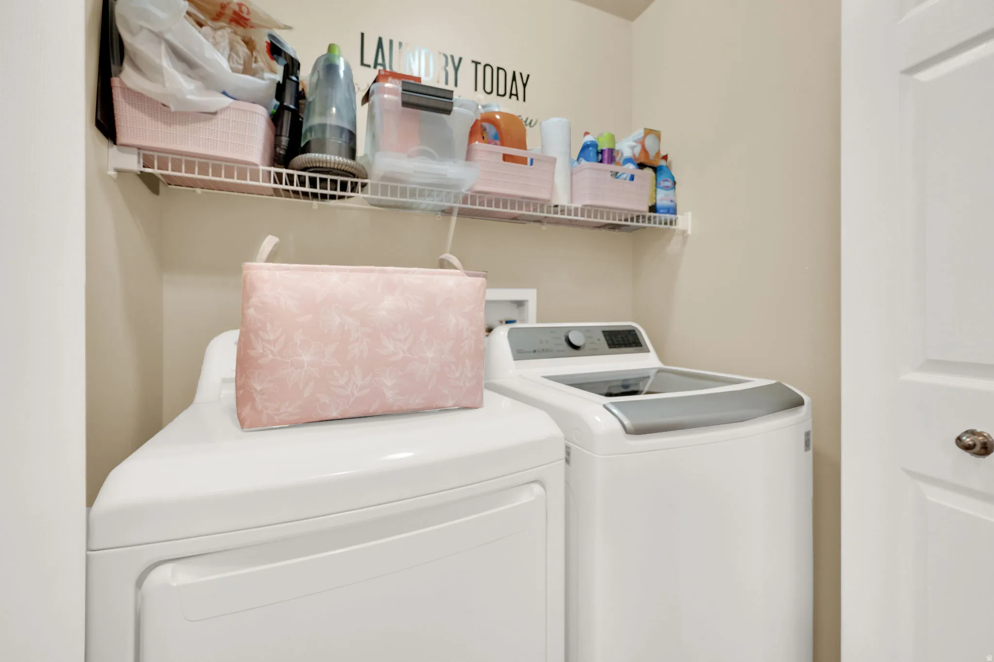 Dedicated laundry area featuring a white wire shelf, neutral wall tones, and a white paneled door
