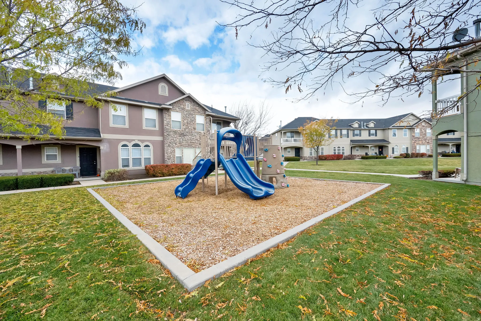 Central playground area featuring blue slides and climbing elements set on a wood chip surface