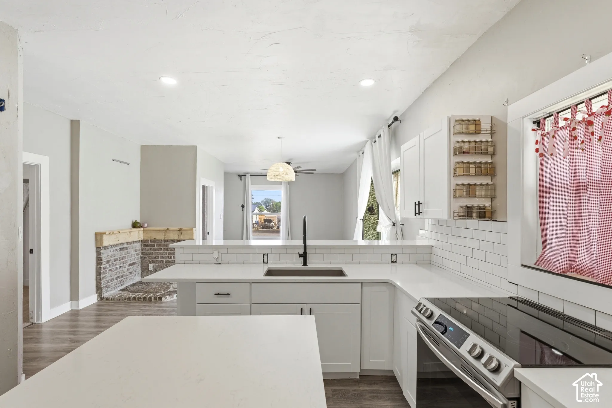 Modern kitchen featuring white cabinetry, light-toned countertops, a stainless steel range, and a subway tile backsplash