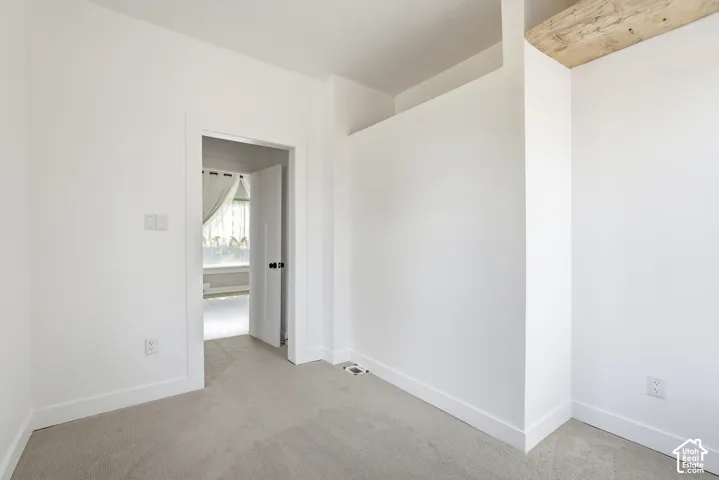 Interior space featuring neutral carpet flooring and white painted walls