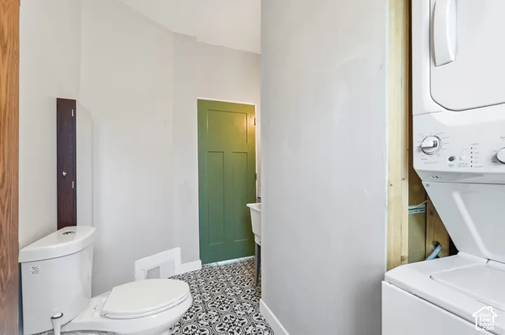 Dedicated laundry area featuring a stacked washer and dryer unit