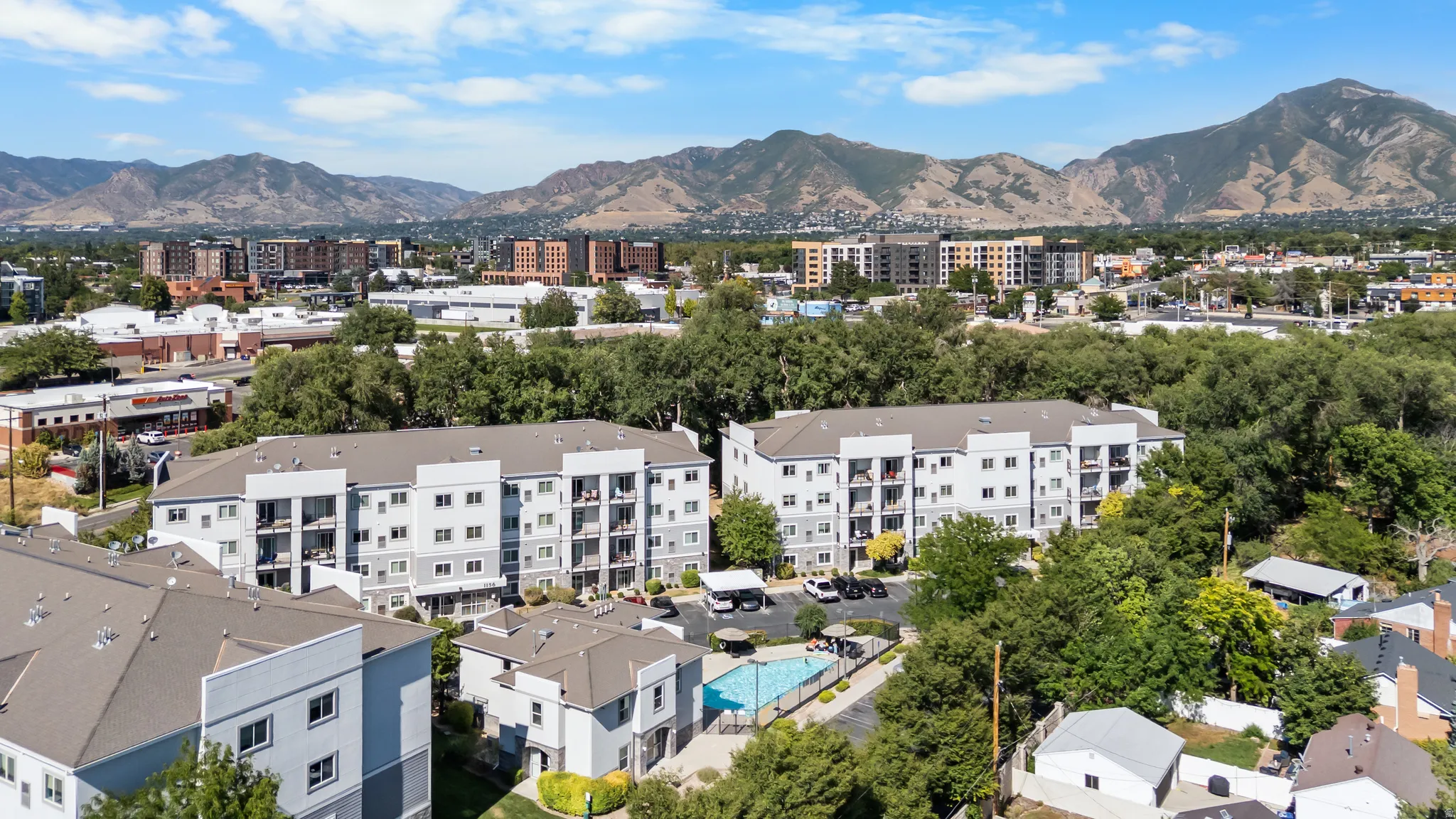Multi-story residential complex featuring multiple buildings with private balconies and a community pool