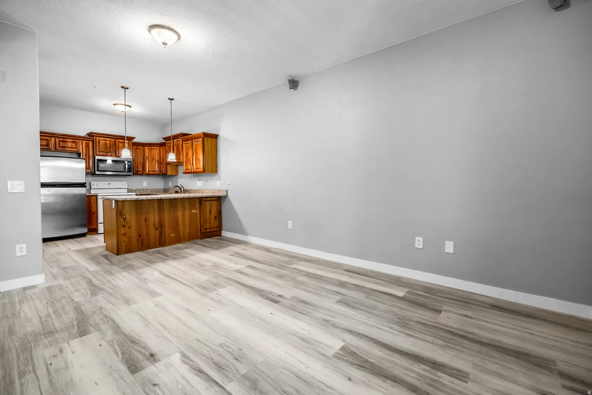 Open-concept living space with light wood-finish flooring