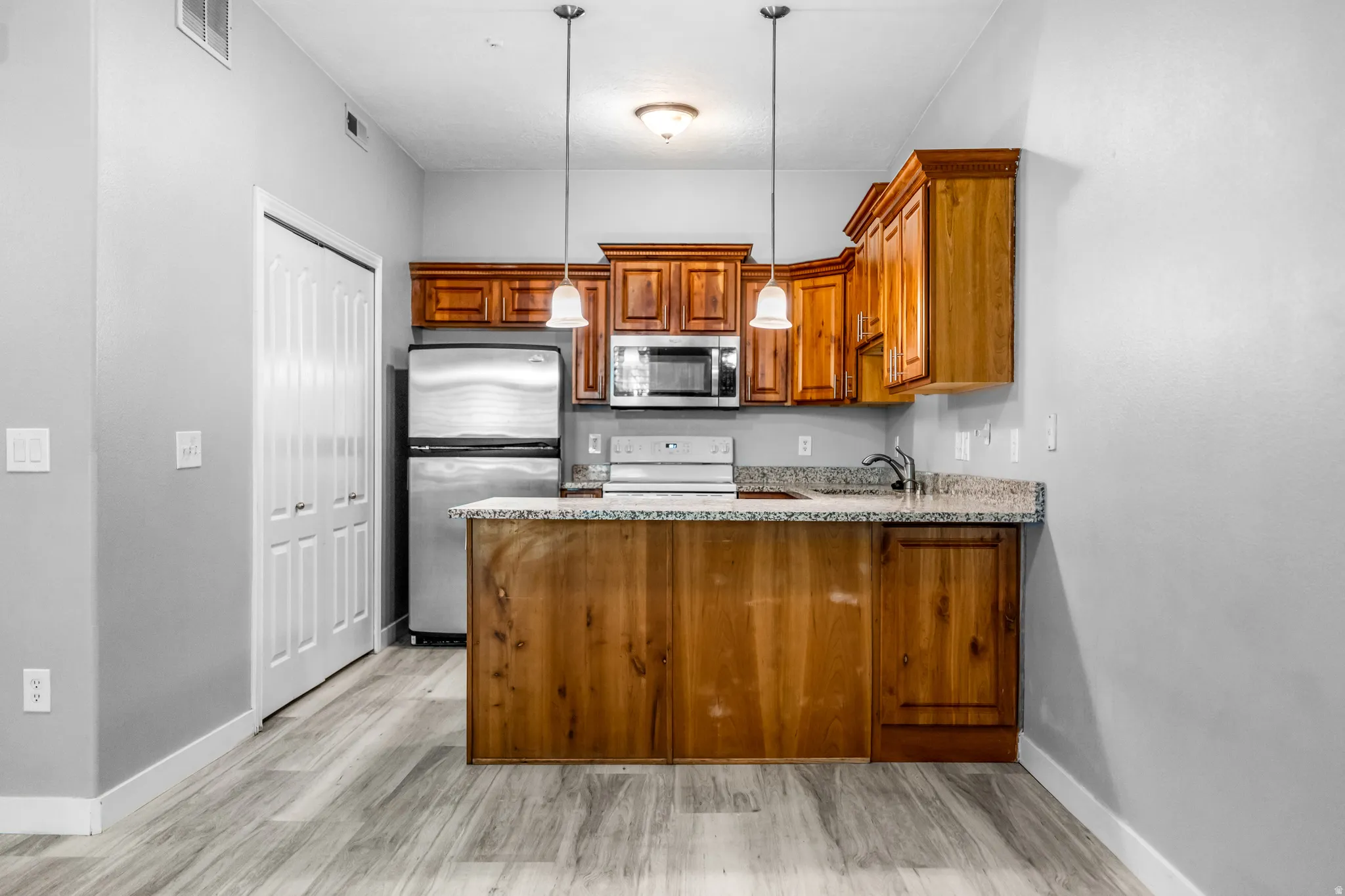 Kitchen featuring wood cabinetry, stainless steel appliances, and granite countertops