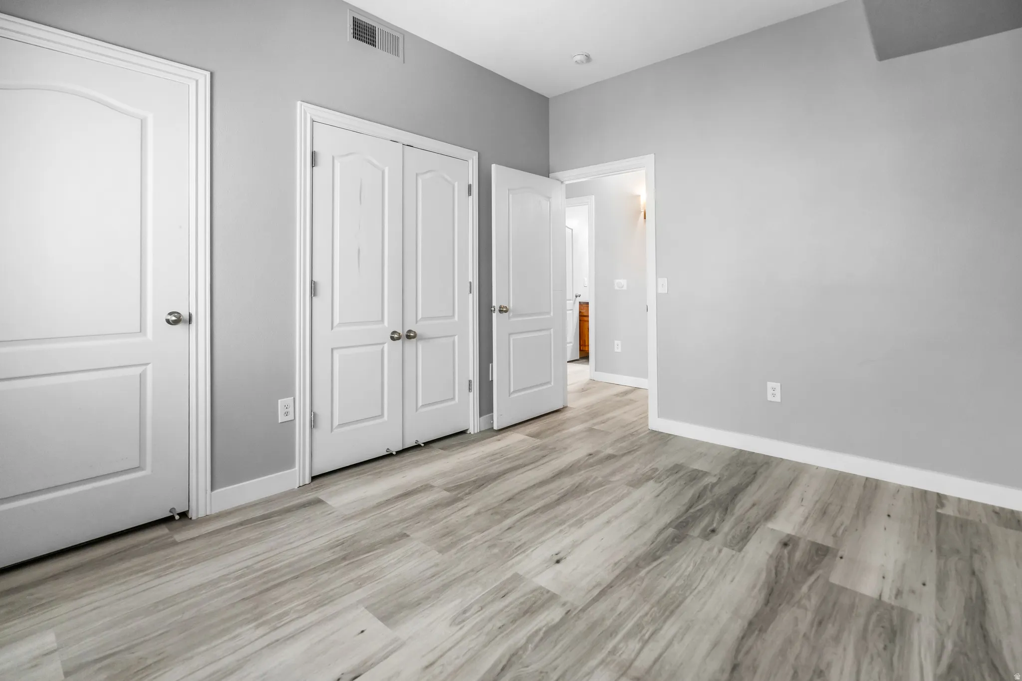 Room featuring light wood-finish flooring, light gray walls, and white trim