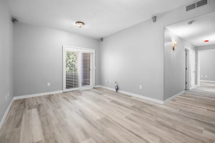 Spacious room featuring wood-finish flooring and light gray walls