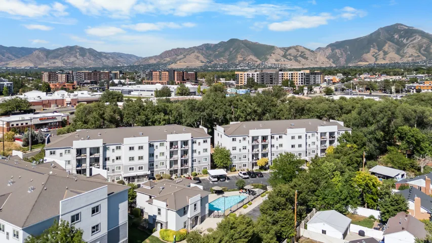 Multi-story residential complex featuring multiple buildings with private balconies and a community pool