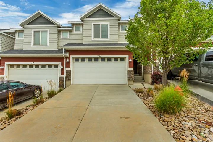 Townhome exterior with light gray siding and red lower facade accents