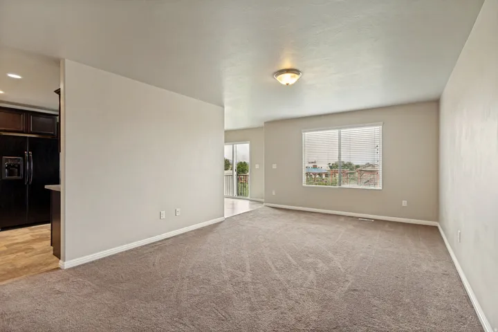 Carpeted interior space featuring neutral wall tones, baseboard molding, and a built-in ceiling light fixture