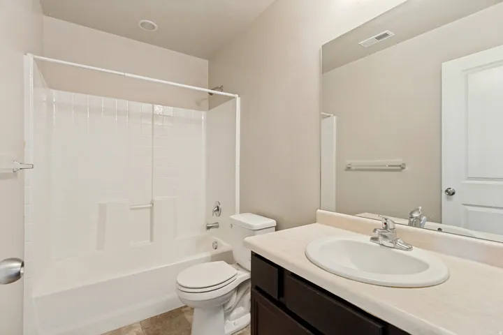 Bathroom featuring a white tub and shower combination with a sliding glass enclosure