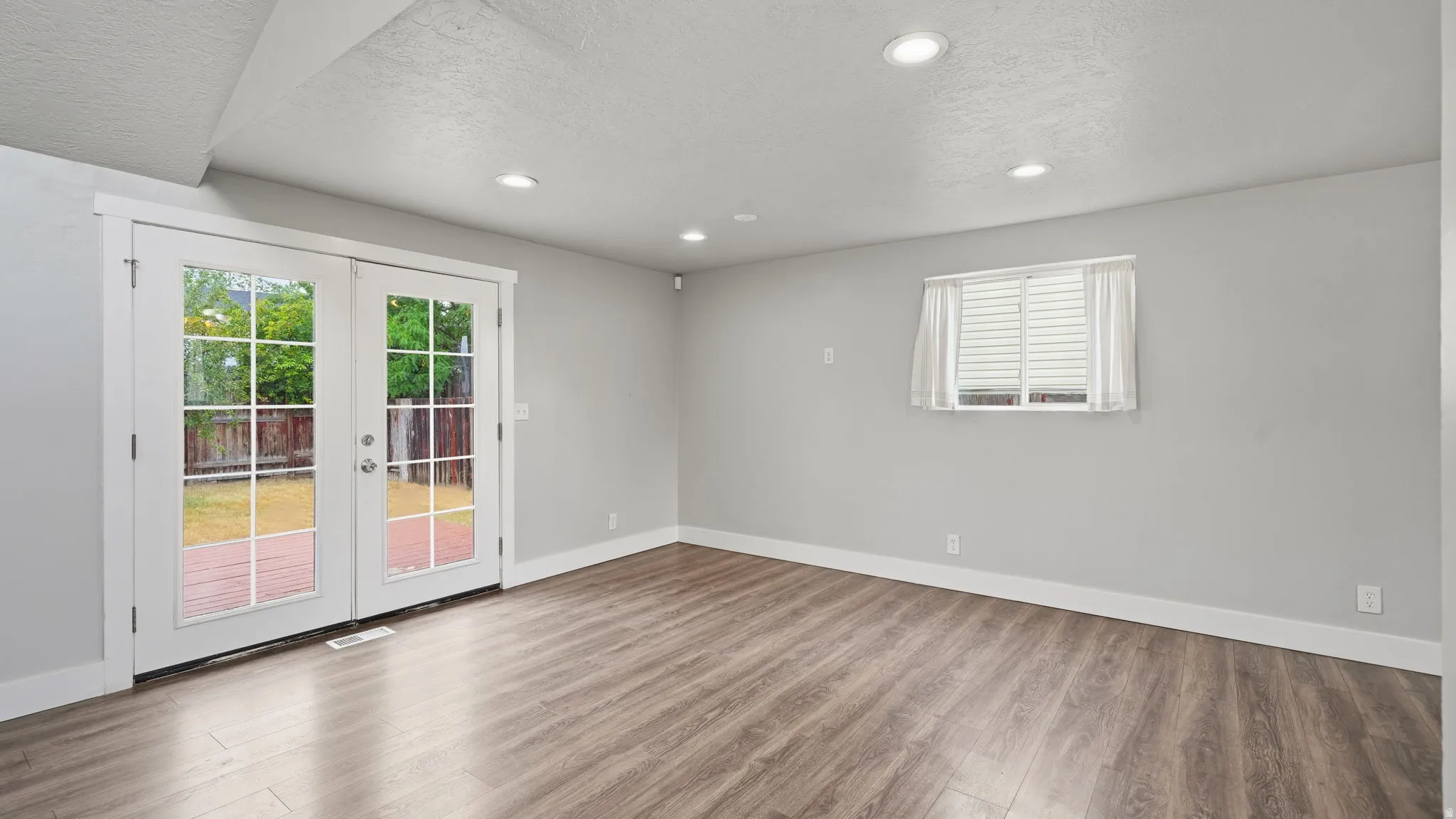 Spacious multi-use gathering room with french doors to the backyard.