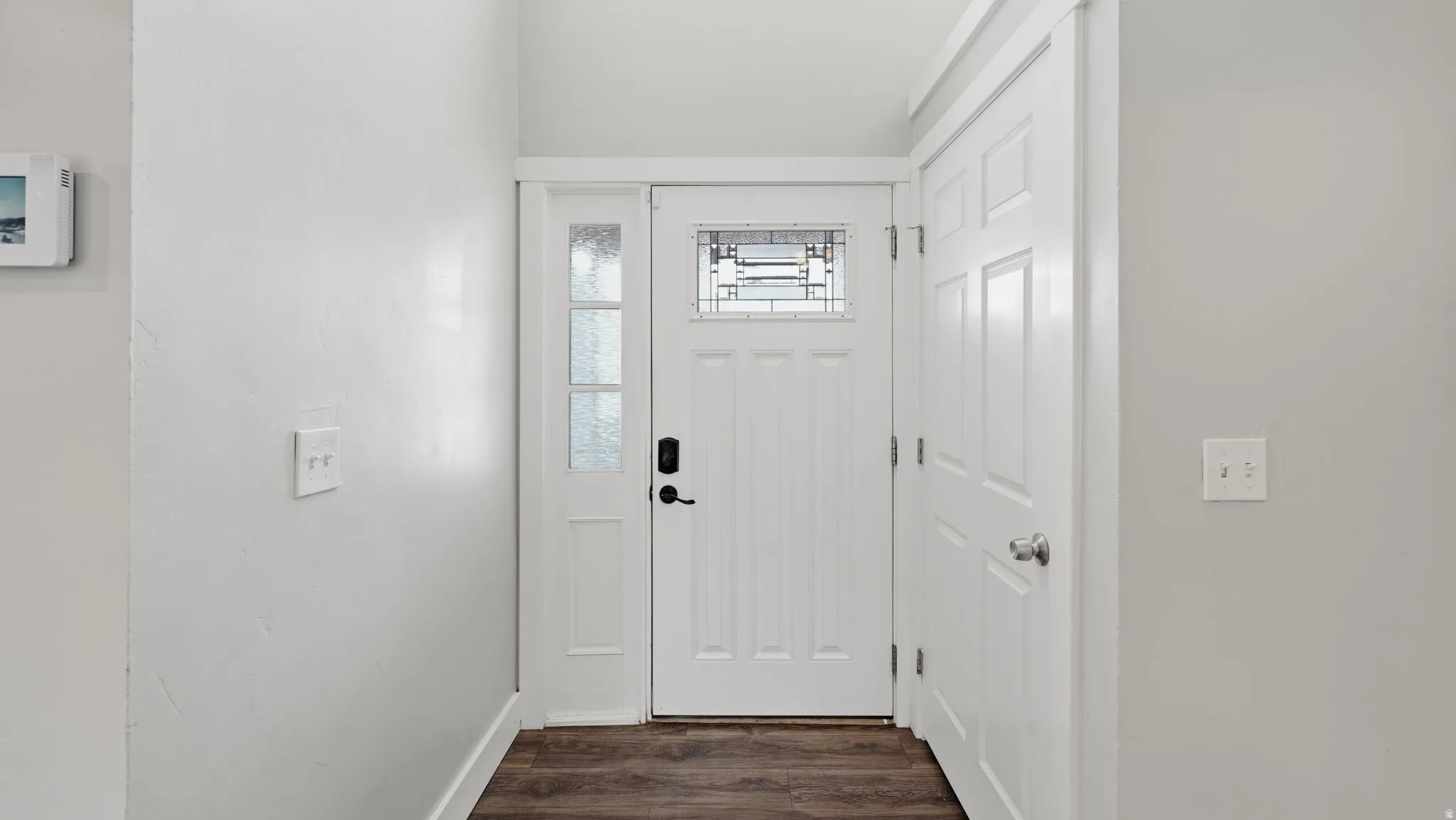 Entryway featuring a white paneled door with decorative glass and closet.