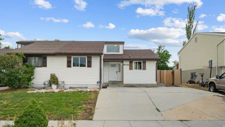 Rambler featuring paid off solar, white siding, dark brown shutters, and a front gabled dormer, East facing driveway means less snow shoveling!